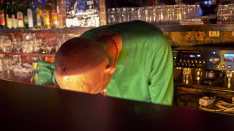 Ein Mann, der an einer Bar mit dem Kopf aufliegt