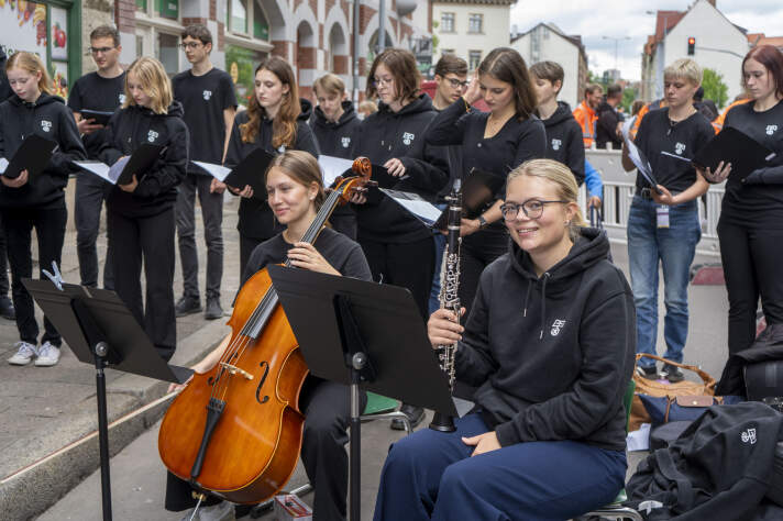 mehrere junge Menschen mit Instrumenten und Gesangsbüchern