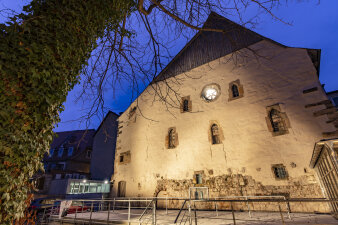 beleuchtete Fassade eines mittelalterlichen Gebäudes in der Dämmerung