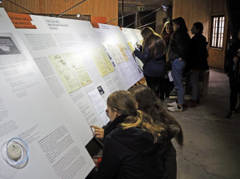 Jugendliche knien oder stehen vor Ausstellungstafeln