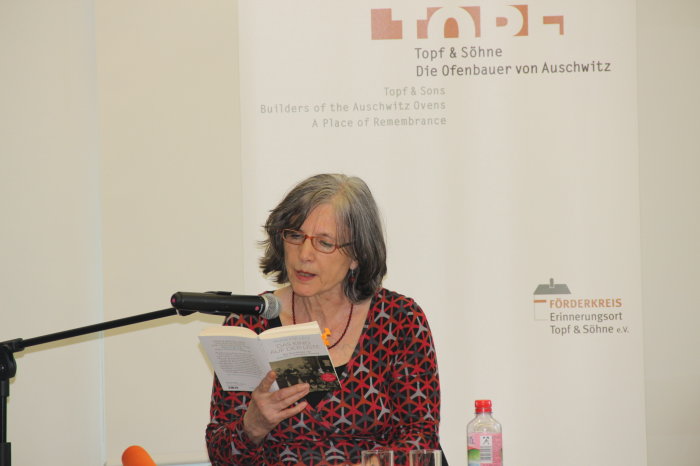 Annette Leo bei einer Veranstaltung im Erinnerungsort Topf & Söhne Eine Frau liest an einem Mikrofon aus einem Buch