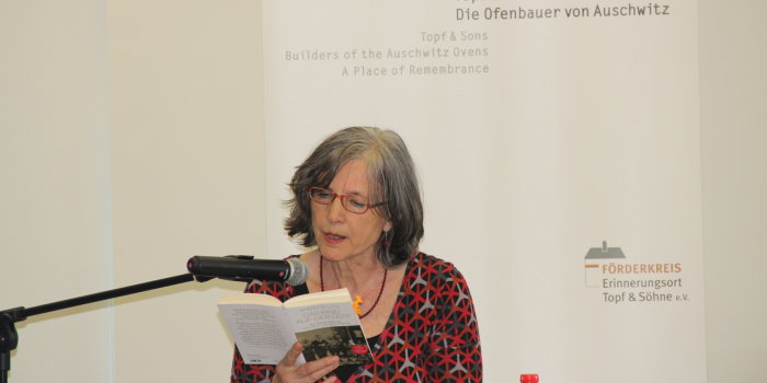 Eine Frau liest an einem Mikrofon aus einem Buch