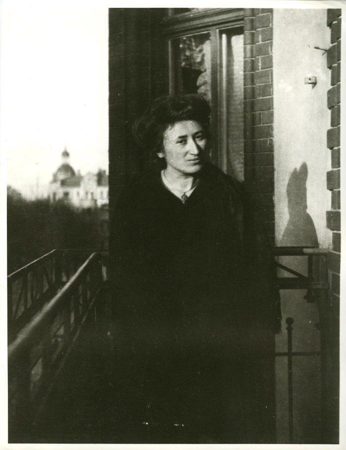 Rosa Luxemburg auf einem Balkon Eine junge Frau steht auf einem Balkon.