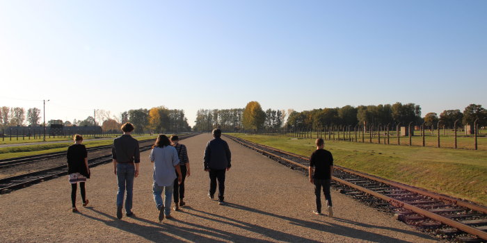 Sechs Personen laufen einen Kiesweg entlang.