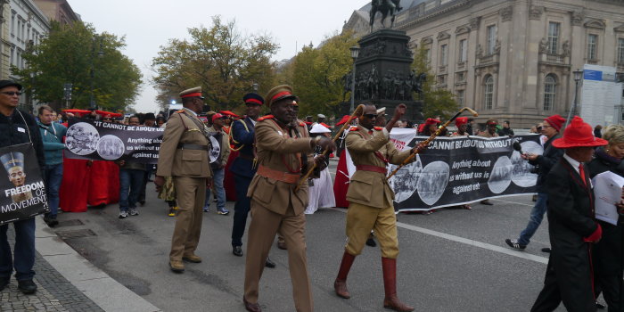 Angehörige der Volksgruppe der Herero und Nama laufen mit Transparenten durch die Berliner Innenstadt. 