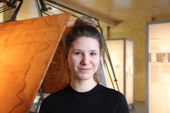 Elisa Möser, Freiwillige im FSJ-Kultur Eine Frau mit schwarzem Oberteil in einer Ausstellung.