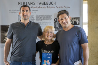 Zwei Männer und eine Frau vor einem Banner mit der Aufschrift Miriams Tagebuch