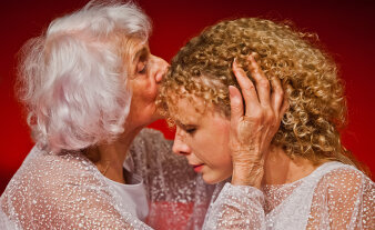 eine ältere Frau küsste eine jüngere Frau auf die Stirn
