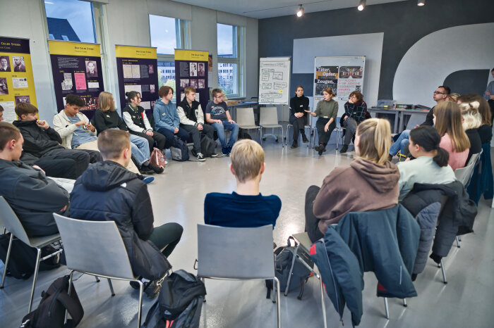 Seminar im Erinnerungsort Topf & Söhne mehrere Jugendliche die im Kreis sitzen, einer davon hält einen Vortrag