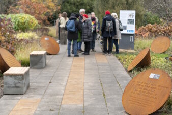 Mehrere Personen in einer Grünanlage mit Metallinstallationen 