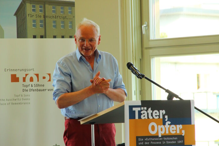 Götz Aly Mann hinter einem Mikrofon der eine Rede hält
