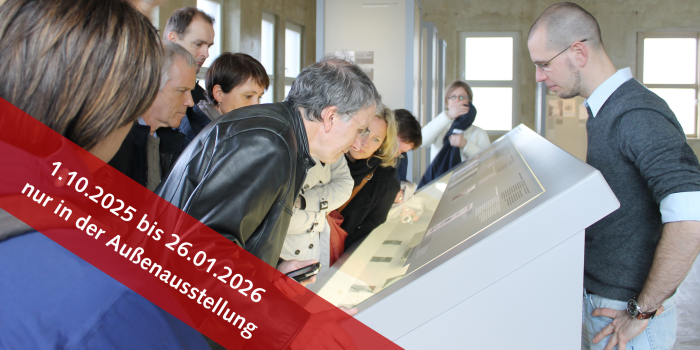 Personen in einer Ausstellung die sich eine Vitrine ansehen