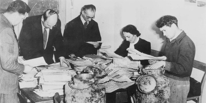 Schwarz Weiß Foto von fünf Personen an einem Tisch 