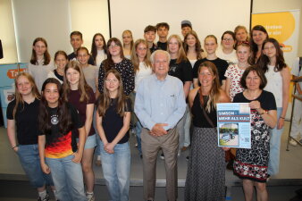 Gruppenbild einer Schulklasse mit Lehrerin und Dennis Baum, dem Sprecher und Nachfahren der Familie Simson.