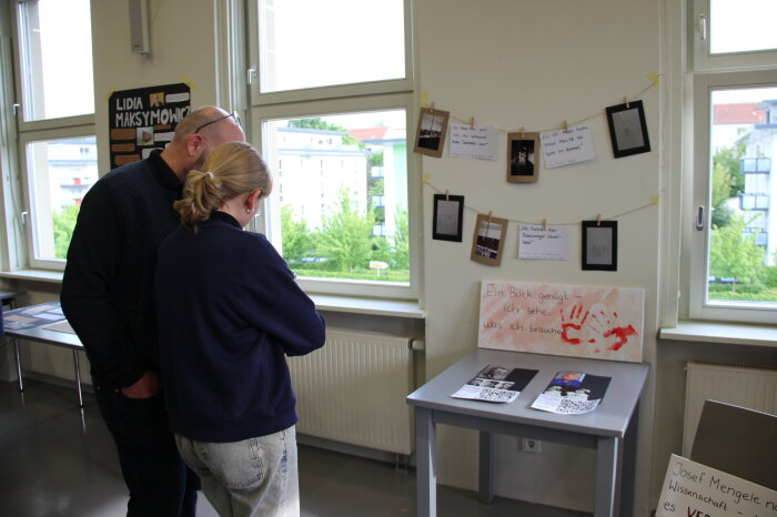 Mann und Frau schauen sich Bilder einer Ausstellung an.