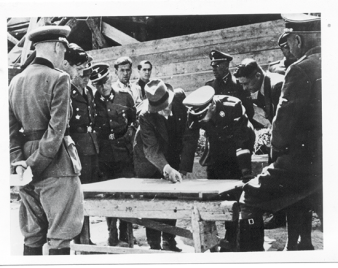 Several uniformed men standing around a table