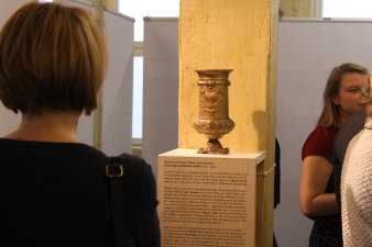 Farbfoto, Frau steht vor einem Pokal