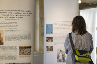 eine Person steht vor Schautafeln in einer Ausstellung