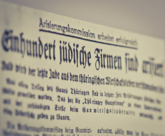 Ausschnitt einer Zeitungsseite in altdeutscher Druckschrift. Bildränder sind leicht verschwommen.Titel des Zeitungsartikel lesbar: Arisierungskommission arbeitet erfolgreich. Einhundert jüdische Firmen sind arisiert