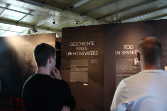 Zwei Männer betrachten Ausstellungstafeln.