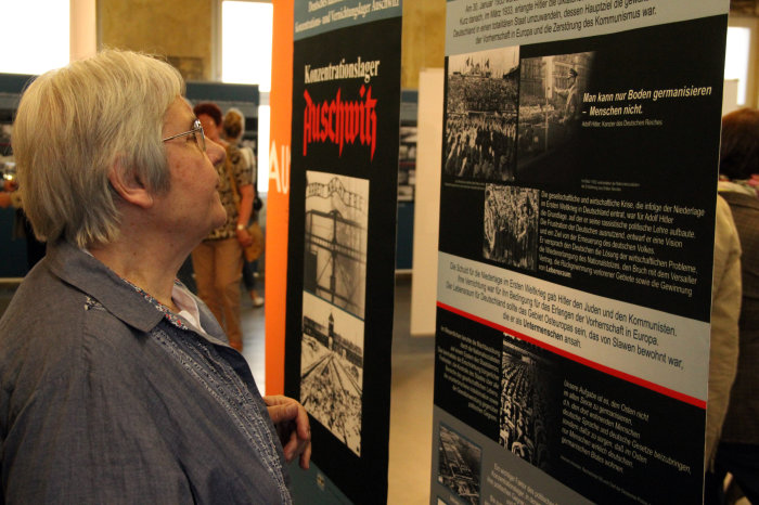 Besucherin in der Ausstellung "Auschwitz" Frau schaut sich eine Tafel an