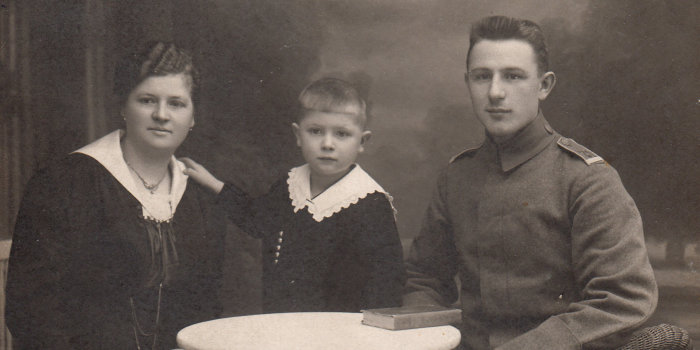 Schwarz-weiß Fotografie eines Soldaten mit Kind und Frau