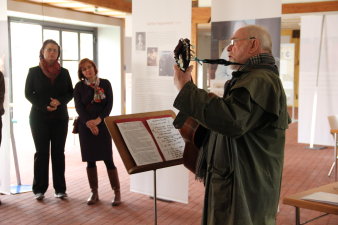 Farbfoto, Mann mit Gitarre, im Hintergrund zwei Frauen