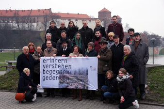 größere Gruppe steht zusammen und hält Banner mit Schriftzug "erinnern verstehen begegnen gedenken"