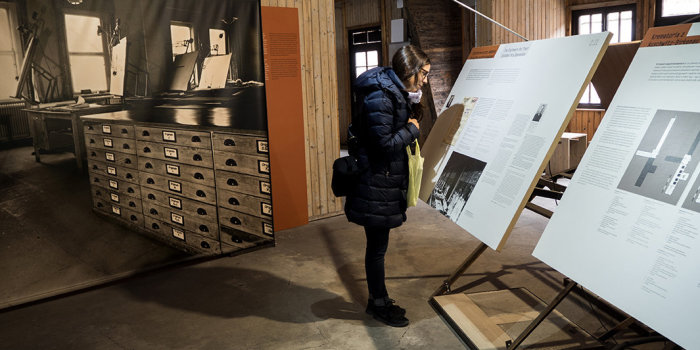 Junge Frau steht in einem Raum mit verschiedenen Ausstellungsträgern