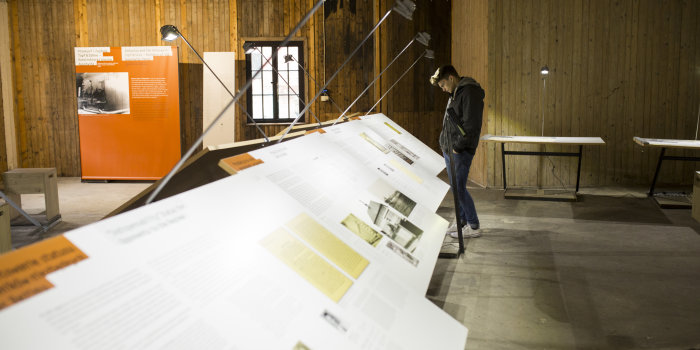 A person standing in front of exhibition panels, reading