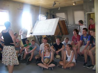 Gruppe von Jugendlichen sitzt vor zwei historischen Zeichenmaschinen.