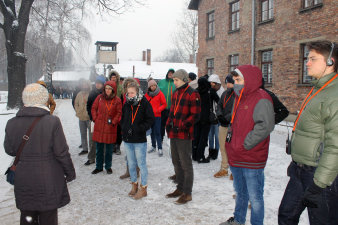 Farbfoto, Gruppe mit Kopfhörern in einem Außengelände, Schnee