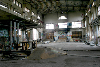 Leere und verwahrloste Halle von innen mit Graffiti an den Wänden