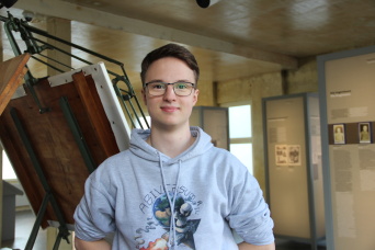 Theo Schubert FSJ 2021 Ein Mann steht vor einem Zeichentisch in einer Ausstellung