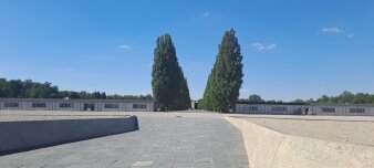 Foto: Gelände der KZ Gedenkstätte Dachau © Erinnerungsort Topf & Söhne gepflasterte Fläche im Hintergrund eine Baumallee